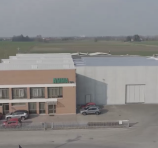 Vista esterna del capannone ampliato di Amma spa, mostrante miglioramenti nell'organizzazione e accesso alle materie prime