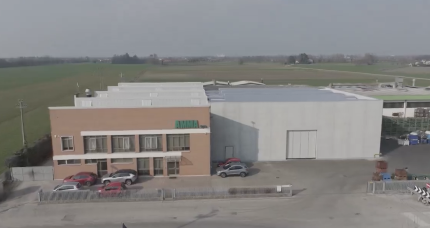 Vista esterna del capannone ampliato di Amma spa, mostrante miglioramenti nell'organizzazione e accesso alle materie prime